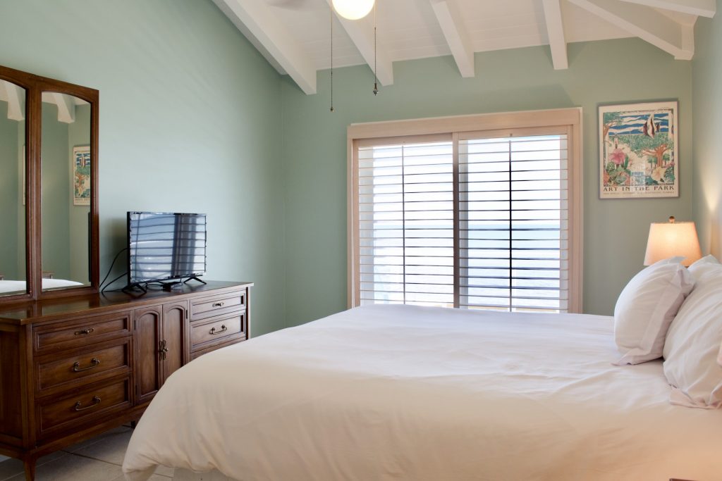 guest bedroom with sliding glass doors and ocean views