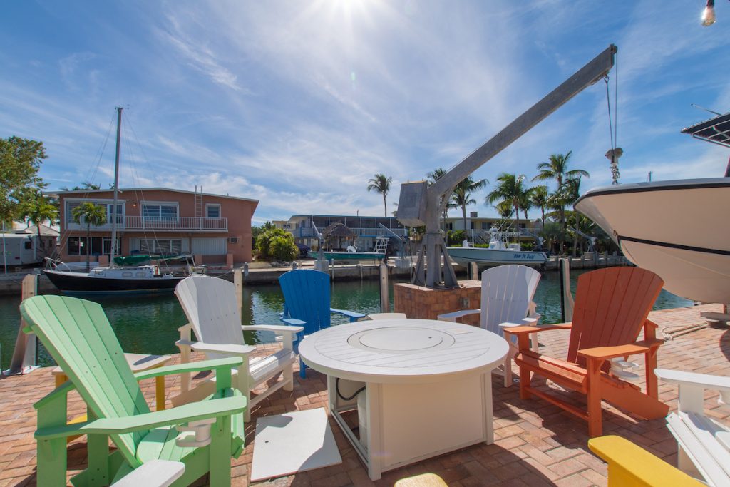 colorful dockside chairs with fire pit on canal front patio