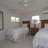 twin beds with clean crisp white linen and rattan furniture
